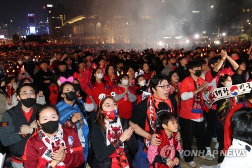 资料图片：11月24日下午，在首尔钟路区的光化门广场，韩国球迷“红魔”为太极军团加油助威。2022卡塔尔世界杯H组小组赛韩国对阵乌拉圭的第一轮比赛当天在卡塔尔赖扬教育城体育场举行。 韩联社