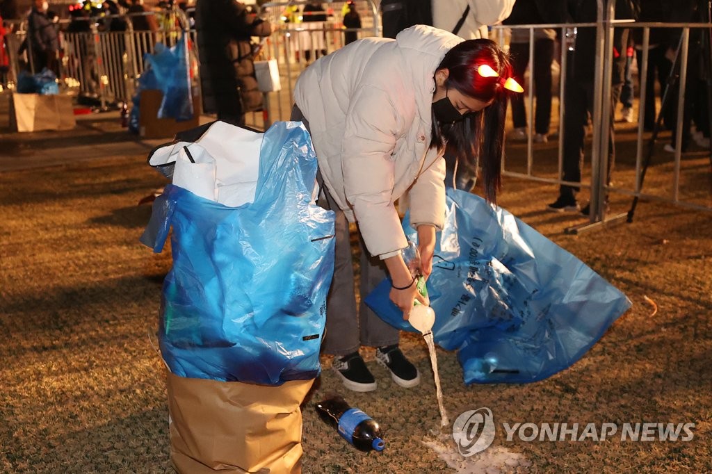 11月24日，2022卡塔尔世界杯韩国队首场比赛的街头助威活动在首尔光化门广场举行。图为市民在助威活动结束后主动捡垃圾。 韩联社
