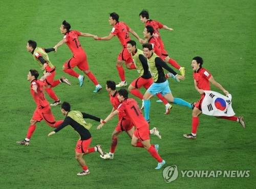 韩国时间12月3日凌晨，在卡塔尔赖扬教育城体育场进行的2022卡塔尔世界杯H组第三轮比赛中，韩国队击败葡萄牙队成功晋级16强。图为韩国代表队举国旗庆祝晋级。 韩联社