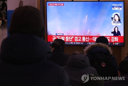 资料图片：12月5日，在首尔火车站的候车室，市民正在收看有关朝鲜发射炮弹的新闻。 韩联社