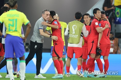 12月6日凌晨，在卡塔尔多哈的974球场，韩国队主教练本托（灰衣）在赛后安慰球员。韩国此役1-4不敌巴西，止步16强。 韩联社