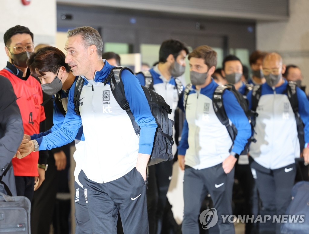 12月7日，在仁川国际机场，韩国男足主帅保罗·本托（前排左一）与前来欢迎的人群握手致意。韩国男足结束2022卡塔尔世界杯征程，当天乘机回国。在本届世界杯上，韩国男足创下时隔12年晋级16强的佳绩。 韩联社