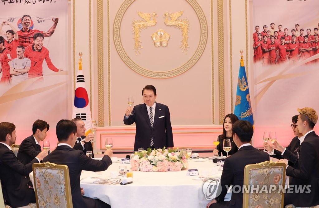 12月8日，在青瓦台迎宾馆，韩国总统尹锡悦邀请国足共进晚餐。图为尹锡悦在席间站起来提议干杯。 韩联社