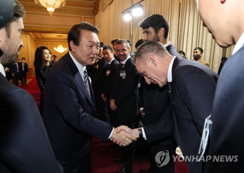12月8日，在青瓦台迎宾馆，韩国总统尹锡悦（左二）与国足主帅保罗·本托握手致意。尹锡悦当天设宴欢迎国足回归。 韩联社
