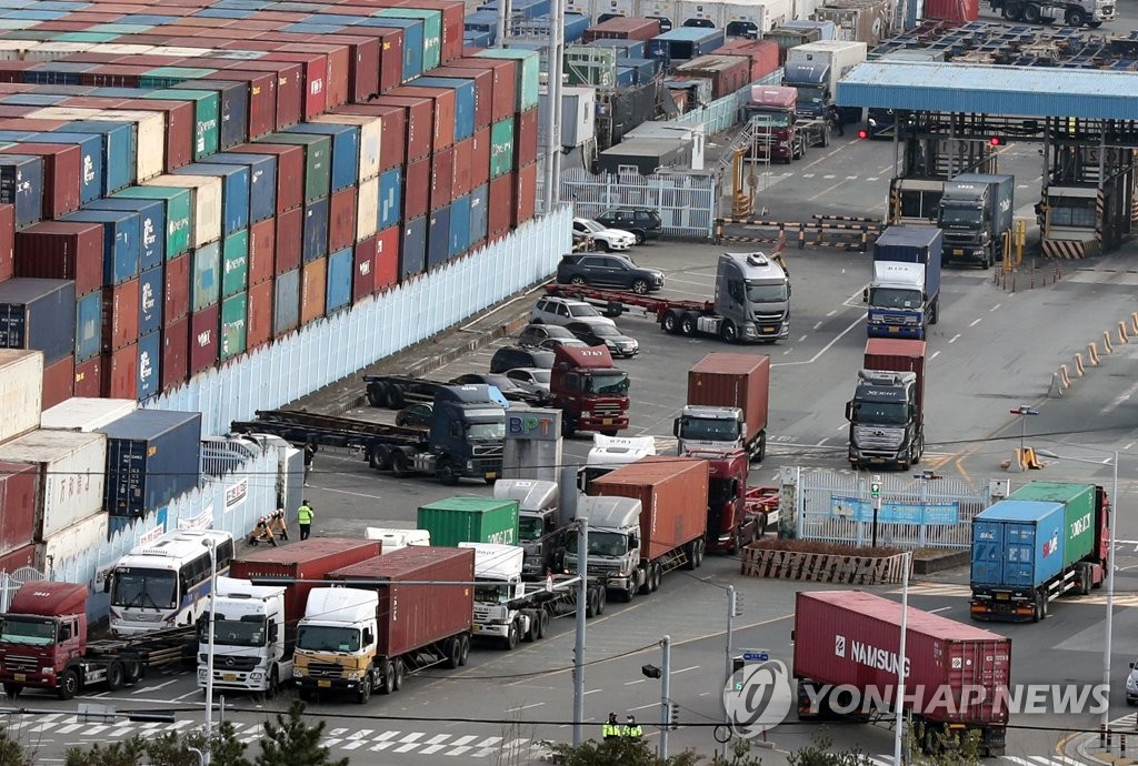 资料图片：12月9日，在釜山南区的神仙台码头，装载集装箱的货车通行繁忙。 韩联社