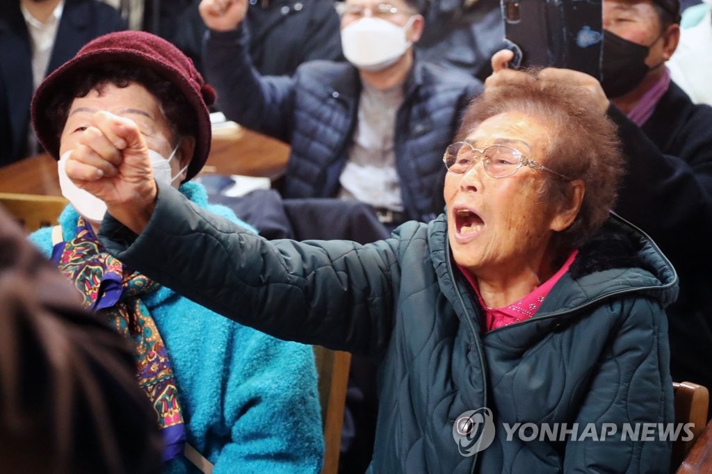 资料图片：12月11日，在光州市，日本强征劳工受害者梁锦德（右）在太平洋战争牺牲者光州遗属会主席李金珠的悼念仪式上呼喊口号。 韩联社