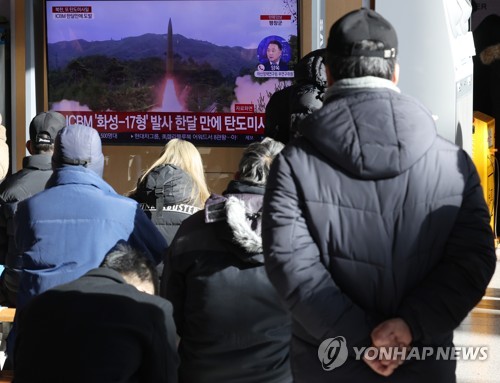 资料图片：12月18日，在首尔火车站候车室，市民观看朝鲜射弹新闻。 韩联社