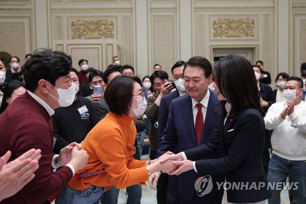 12月20日，在青瓦台迎宾馆，韩国总统尹锡悦和夫人金建希邀请青年代表举行座谈会，讨论三大改革课题。图为尹锡悦夫妇同与会者握手致意。 韩联社/总统室供图（图片严禁转载复制）