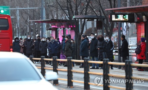 12月23日上午，首尔地铁3号线部分区段隧道内线路起火，列车被迫停运1小时30多分钟，给严冬中上班出行的市民带来诸多不便。图为市民们在独立门站公交车站排队等车。 韩联社