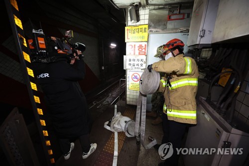 12月23日上午，首尔地铁3号线部分区段隧道内线路起火，列车被迫停运1小时30多分钟。图为消防队员在独立门站抢修。 韩联社