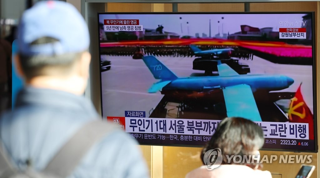 资料图片：12月27日，在首尔站候车室，人们观看朝鲜无人机侵犯领空的电视报道。 韩联社