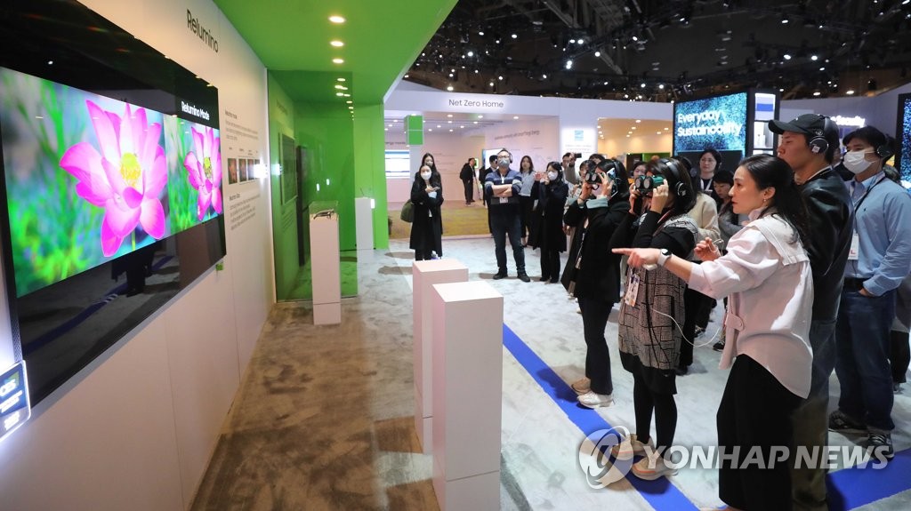 资料图片：不少访客正体验三星电子CES展区展出的电视新品。 韩联社