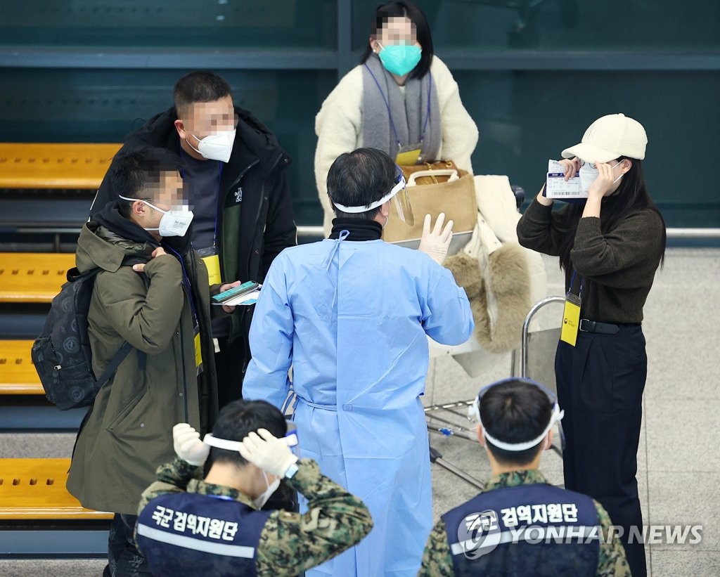 1月8日下午，在仁川机场国际到达大厅，工作人员向来自中国的游客说明检疫流程。 韩联社