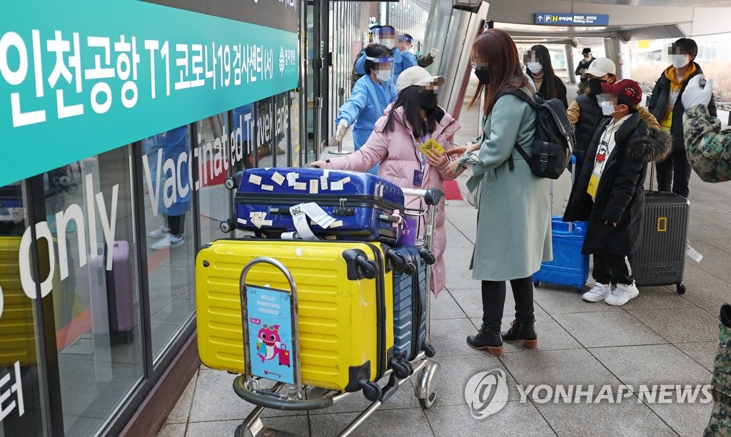 资料图片：1月8日，在仁川国际机场第一航站楼，自华入境人员走向新冠筛查中心。 韩联社