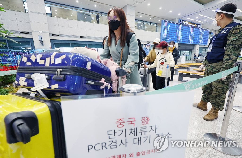 资料图片：1月8日，在仁川国际机场，自华入境人员下机后前往新冠检测中心。 韩联社