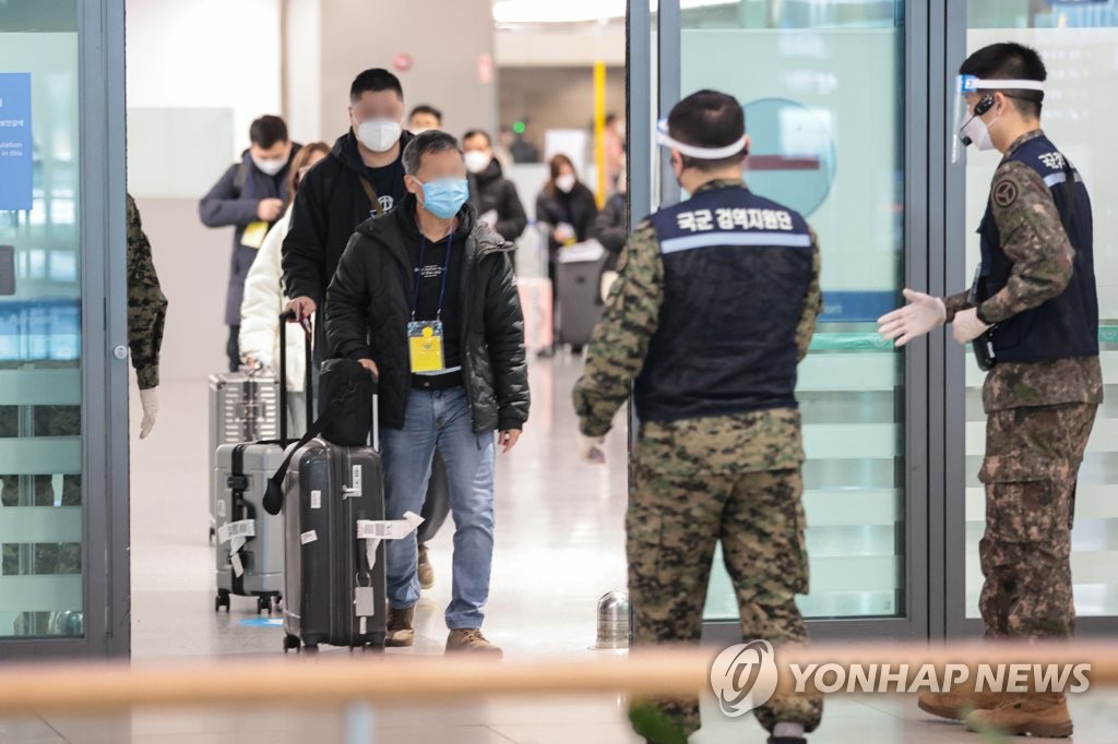 资料图片：1月9日，在仁川国际机场第一航站楼，自华入境人士正按照防疫人员的指示入境。 韩联社