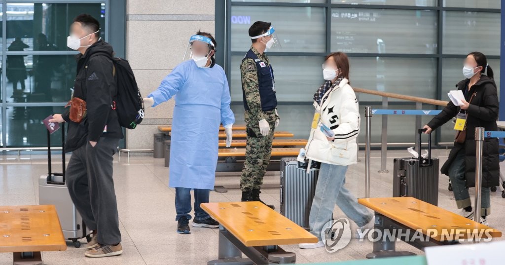 1月9日，在仁川国际机场第一航站楼，自华入境人士正按照防疫人员的指示入境。 韩联社