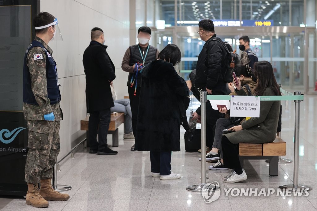 资料图片：1月9日，在仁川国际机场第二航站楼，来自中国的入境人员正在等待接受核酸检测。 韩联社