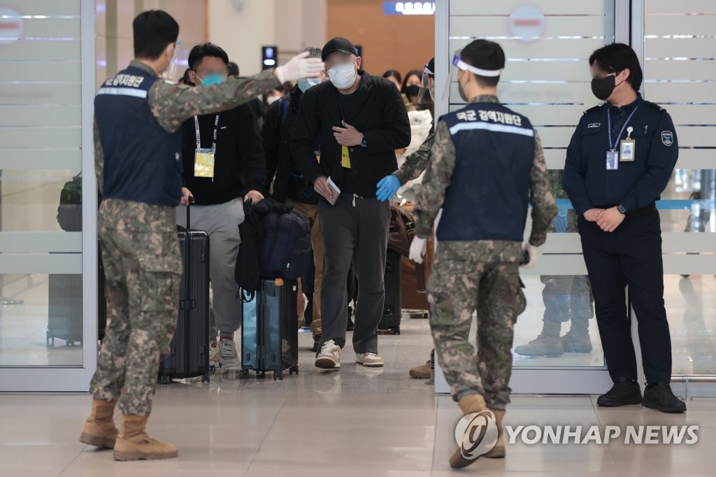 资料图片：2023年1月9日，在仁川国际机上第二航站楼，韩国防疫人员指引自华入境人员前往落地检诊所。 韩联社