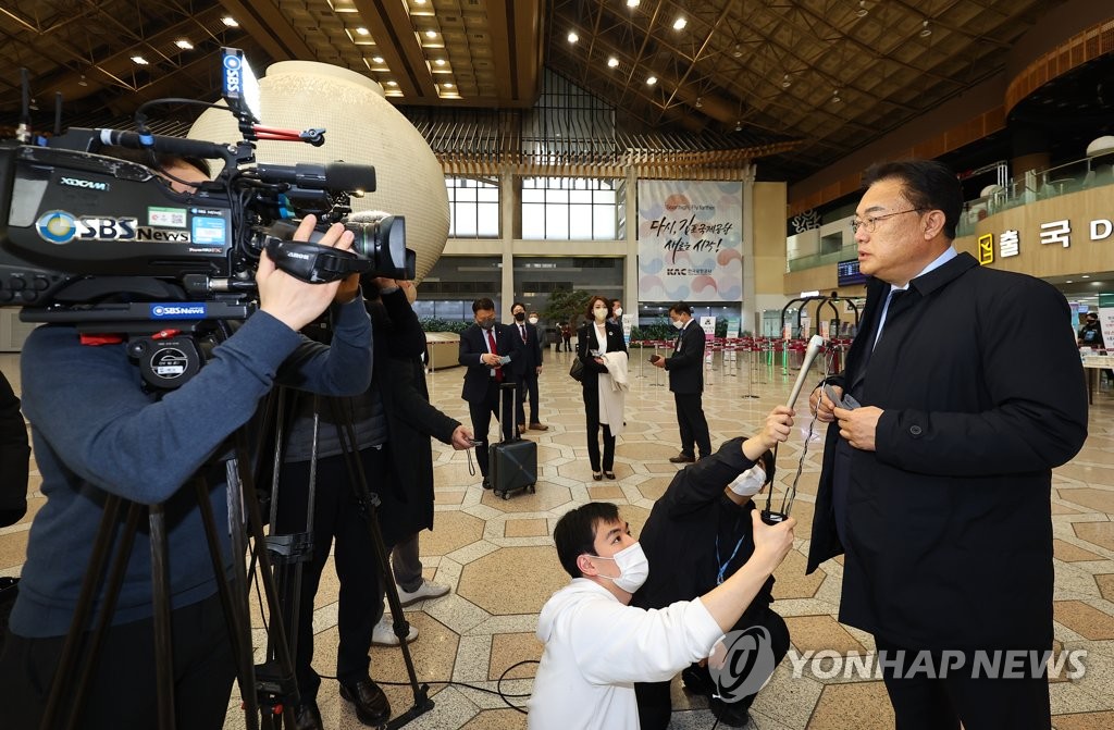 资料图片：1月12日，在首尔金浦国际机场，韩日议员联盟主席郑镇硕（右）启程前接受记者采访。 韩联社