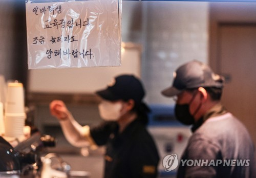资料图片：一家咖啡厅贴出新员工接受培训通告。 韩联社