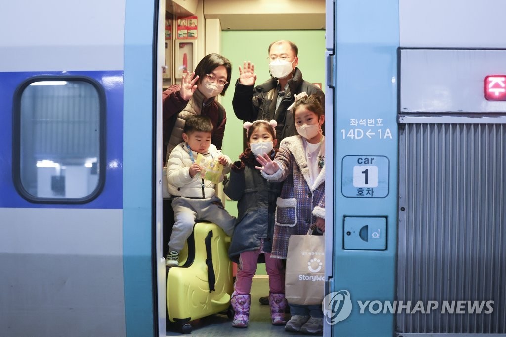 1月20日，在首尔火车站，小朋友们和父母一起坐火车返乡过年。 韩联社