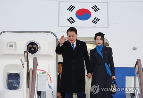 1月21日，结束阿联酋和瑞士访问行程的韩国总统尹锡悦（左）和夫人金建希搭乘专机“空军一号”抵达京畿道城南市的首尔机场。 韩联社