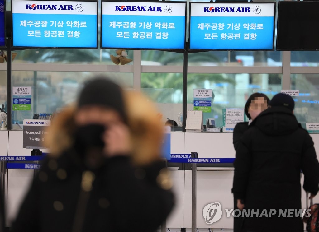 资料图片：1月24日，济州机场大韩航空柜台打出航班取消告示。 韩联社