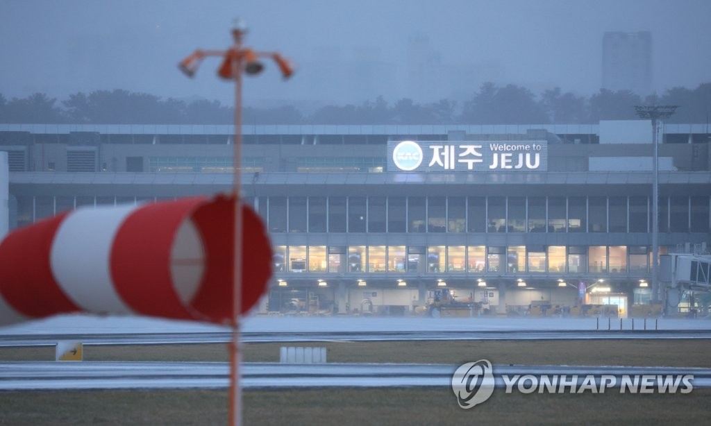 资料图片：1月24日，济州国际机场跑道刮起强风雪。当天是韩国春节小长假的最后一天。 韩联社