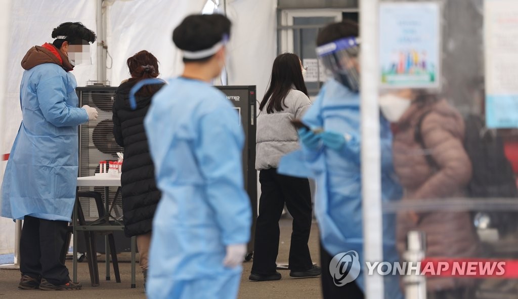 资料图片：1月24日，在首尔站广场的新冠临时筛查诊所，人们正在接受检测。 韩联社