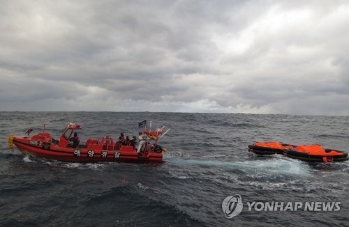 1月25日，在韩日公海，韩国海警正在搜索沉没货轮上的船员。 韩联社/济州海洋警察厅供图（图片严禁转载复制）