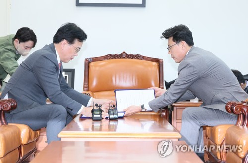 1月25日，在国会，国民力量党鞭宋彦锡（左）和共同民主党党鞭陈声准在临时国会议事日程协议文上签字。 韩联社