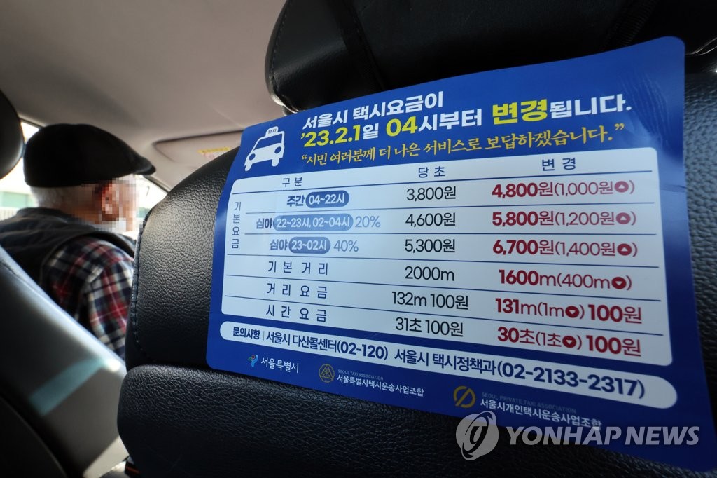 在首尔站附近等待载客的出租车副驾驶座椅背后张贴调表告示。 韩联社