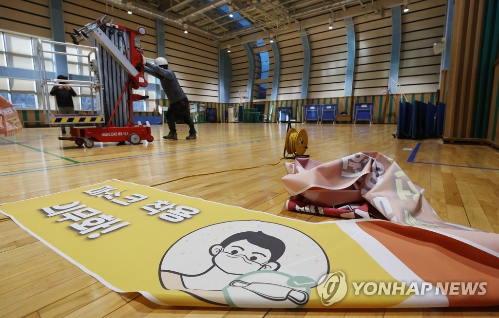 资料图片：韩国一家室内场馆拆除“义务戴口罩”字样横幅。 韩联社