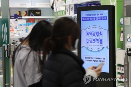 资料图片：1月31日，仁川国际机场一家药店的终端机提示顾客佩戴口罩。 韩联社