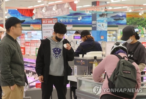 资料图片：1月31日，在首尔市区一大型超市，市民们摘下口罩购物。 韩联社