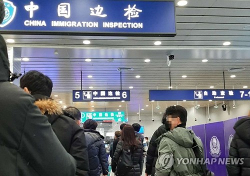 资料图片：2月1日上午，在中国威海，办理入境手续的韩国旅客排起长队。 韩联社/读者供图（图片严禁转载复制）