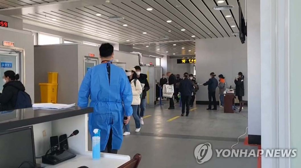 资料图片：2月1日，在中国威海机场，自韩旅客排队接受新冠检测。 韩联社/读者供图（图片严禁转载复制）