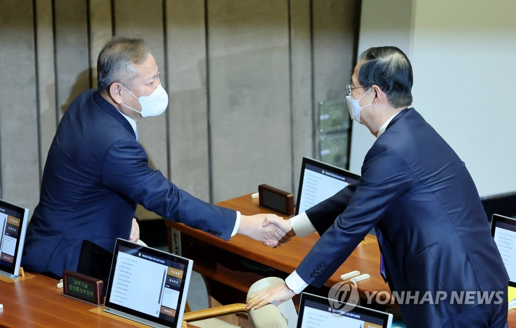 资料图片：2月5日，李祥敏（左）出席国会全体会议时与国务总理韩悳洙握手致意。 韩联社