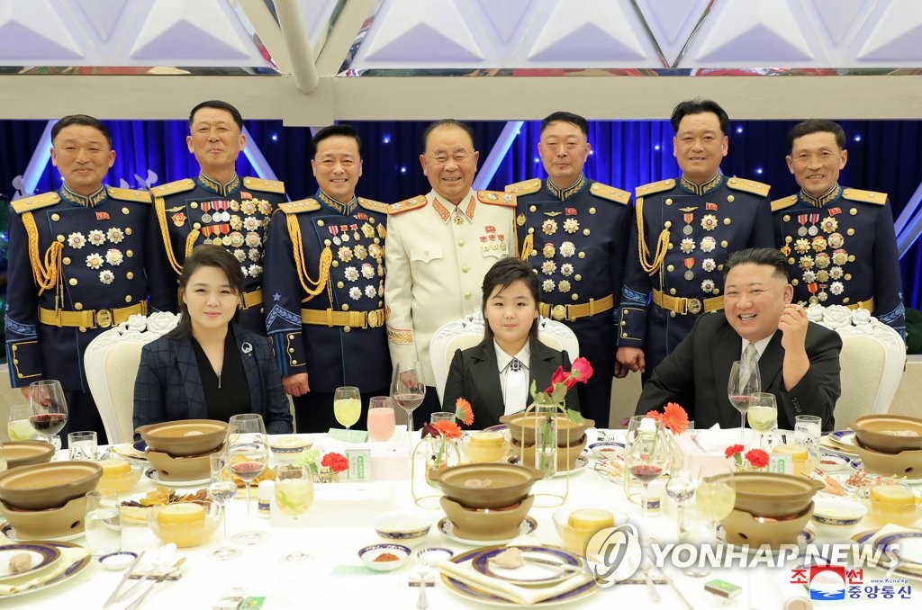 资料图片:据朝中社2月8日报道,国务委员会委员长金正恩(前排右一)前一日与夫人李雪主(前排左一)和女儿金主爱(音,中)出席人民军建军75周年纪念宴会。2月8日是朝鲜人民军建军节。 韩联社/朝中社(图片仅限韩国国内使用,严禁转载复制)