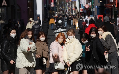资料图片：2月8日，在首尔明洞街头，来韩日本游客合影留念。随着新冠疫情转为季节性流行病，海外游客逐渐回流，明洞街头重现生机。 韩联社