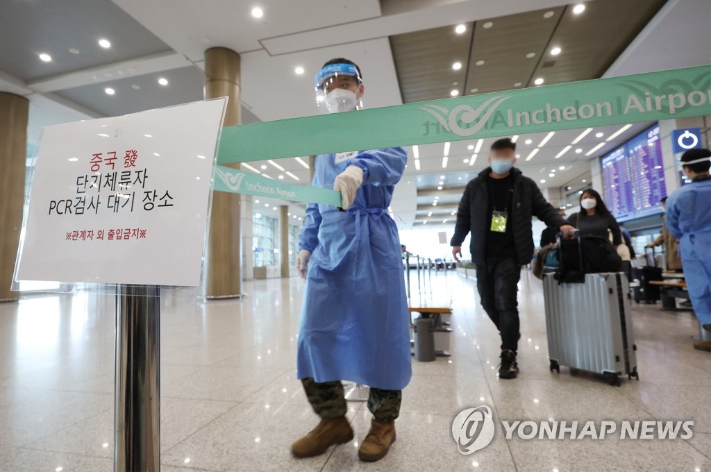 资料图片：2月12日，在仁川国际机场第一航站楼，自华入境旅客们在工作人员的指引下前去接受落地核酸检测。 韩联社