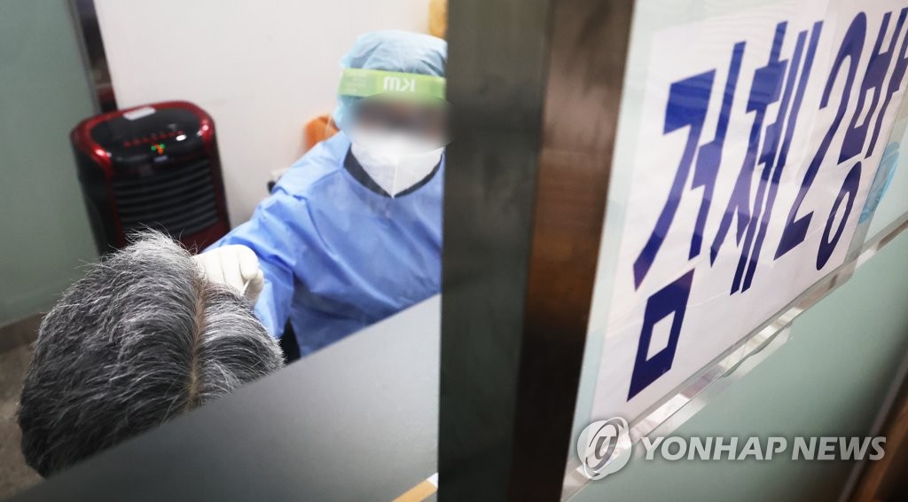 资料图片：2月20日，在位于首尔市麻浦区的卫生站，市民接受新冠核酸检测。 韩联社
