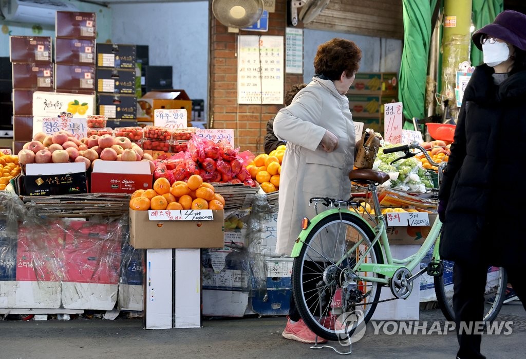 资料图片：2月22日，在首尔麻浦区的望远市场，市民们正在购物。 韩联社