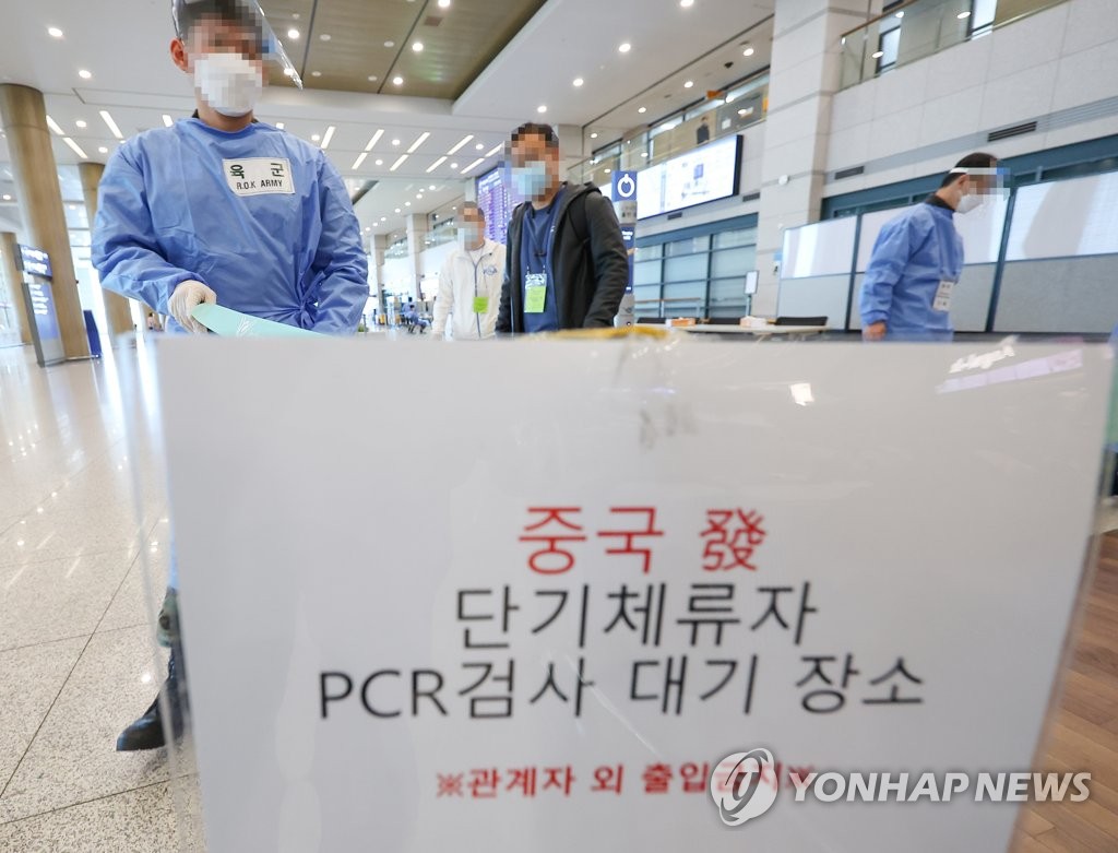 2月27日，在仁川国际机场第一航站楼到达厅，来自中国的入境人员接受工作人员有关核酸检测的指引。 韩联社