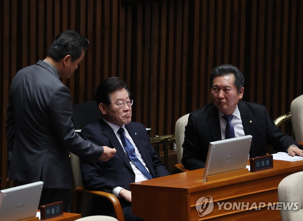 2月27日，韩国最大在野党李在明（左二）出席国会全会。 韩联社