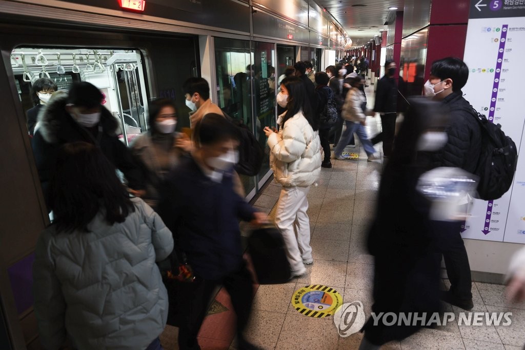 资料图片：3月5日，在首尔地铁五号线，上下车的乘客们都戴着口罩。 韩联社