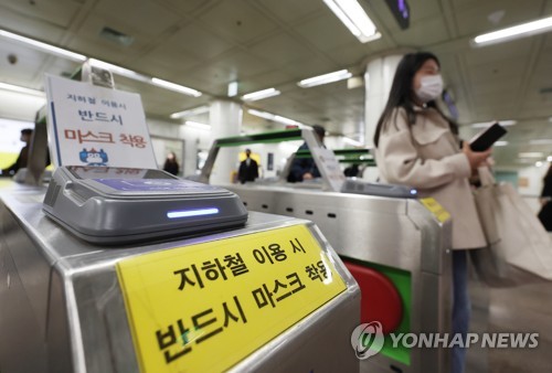 资料图片：3月15日，在首尔光化门地铁站，一名戴口罩的乘客通过检票口。 韩联社