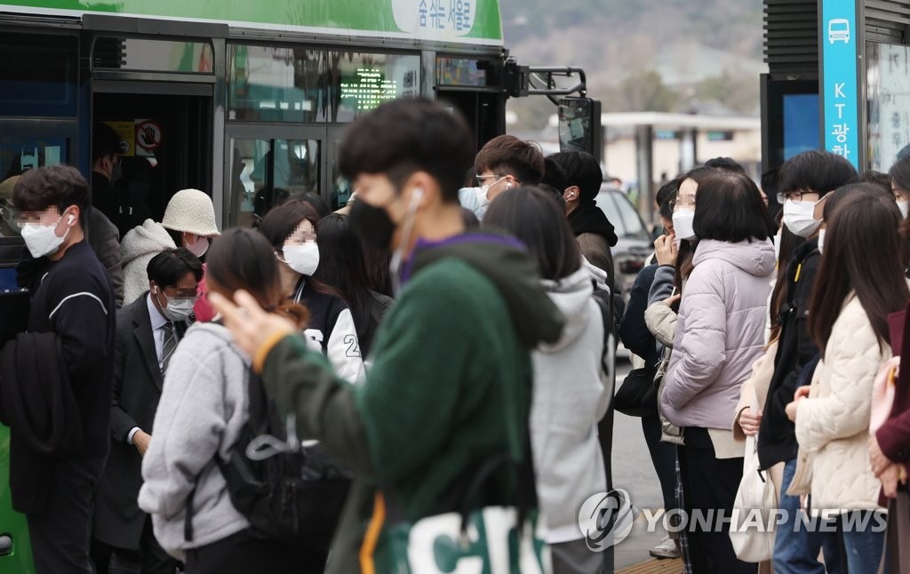 资料图片：3月15日，在首尔市区的一处公交车站，市民戴上口罩利用公交车。 韩联社