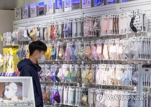 资料图片：3月15日，首尔明洞一家口罩店的柜台上贴着“买三送一”的促销活动通知。 韩联社